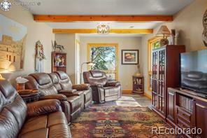 6100 Waterbarrel Rd, Beulah, CO 81023 - living room featuring beamed ceiling and baseboards