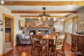 6100 Waterbarrel Rd, Beulah, CO 81023 - dining space featuring wood finished floors, a fireplace, beam ceiling, and baseboards