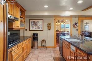 6100 Waterbarrel Rd, Beulah, CO 81023 - kitchen with exhaust hood, a sink, recessed lighting, brown cabinetry, and stainless steel dishwasher