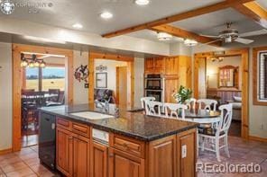 6100 Waterbarrel Rd, Beulah, CO 81023 - kitchen featuring a sink, light tile patterned flooring, a ceiling fan, baseboards, and brown cabinetry
