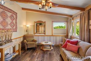 6100 Waterbarrel Rd, Beulah, CO 81023 - sitting room featuring wood finished floors, a chandelier, and wainscoting