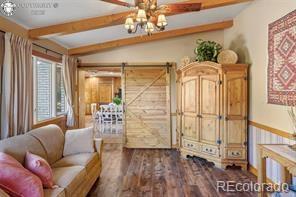 6100 Waterbarrel Rd, Beulah, CO 81023 - sitting room with wood finished floors, beam ceiling, and baseboards