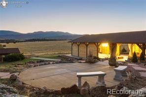 6100 Waterbarrel Rd, Beulah, CO 81023 - patio terrace at dusk featuring a patio and a mountain view
