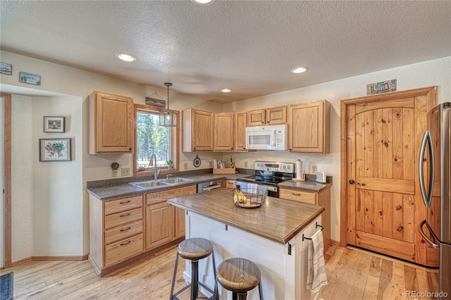 kitchen featuring appliances with stainless steel finishes, light wood-type flooring, wood counters, and a sink