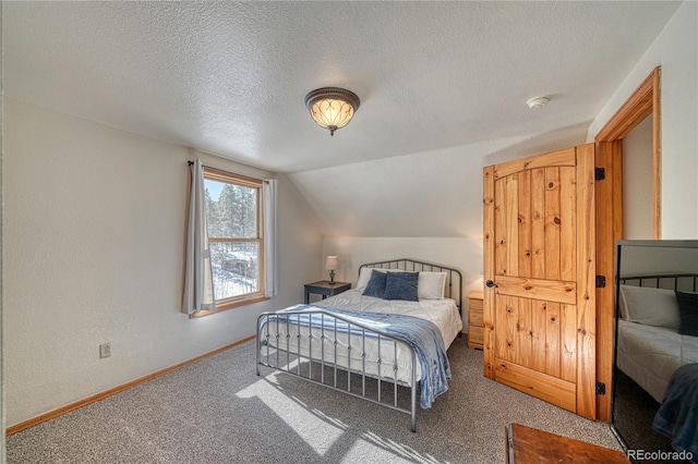 carpeted bedroom with vaulted ceiling, a textured wall, baseboards, and a textured ceiling