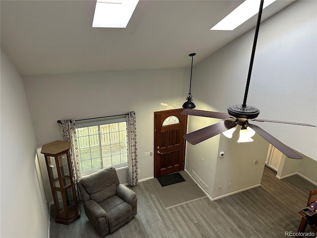 entrance foyer featuring a skylight, high vaulted ceiling, and dark hardwood / wood-style floors