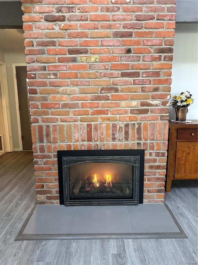 room details with wood-type flooring and a brick fireplace