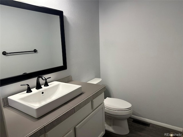 bathroom featuring vanity, hardwood / wood-style floors, and toilet