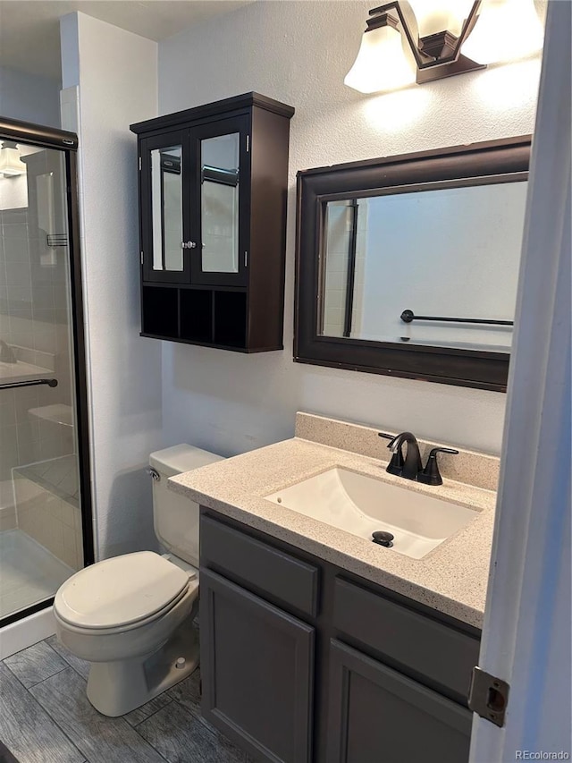 bathroom featuring vanity, toilet, and an enclosed shower