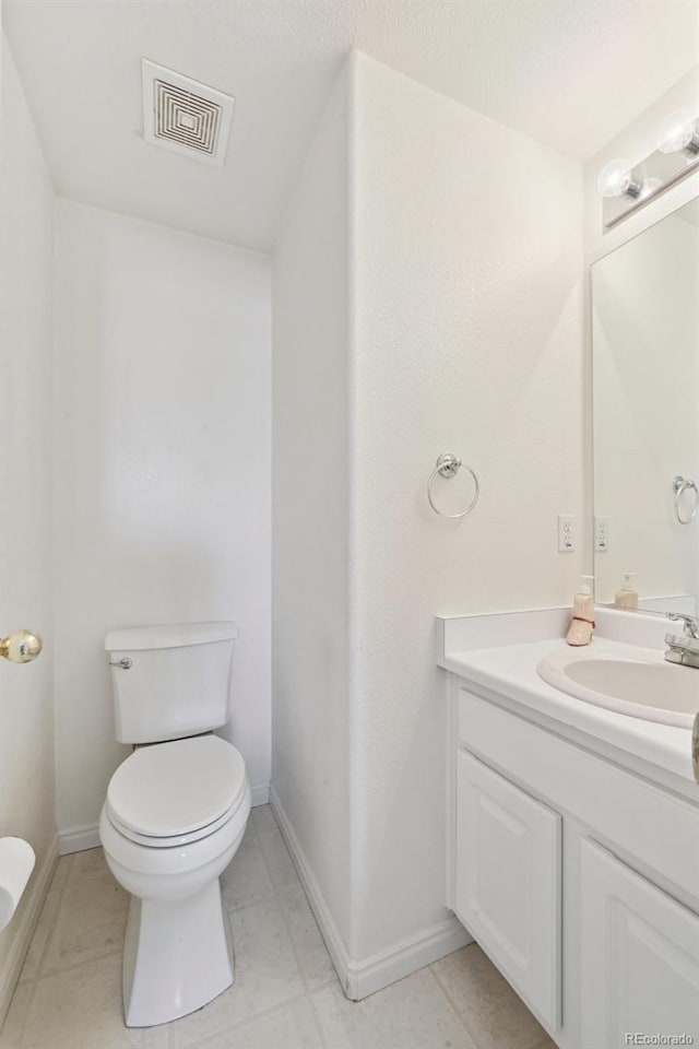 16275 Electra St, Brighton, CO 80603 - bathroom with vanity, baseboards, toilet, and visible vents