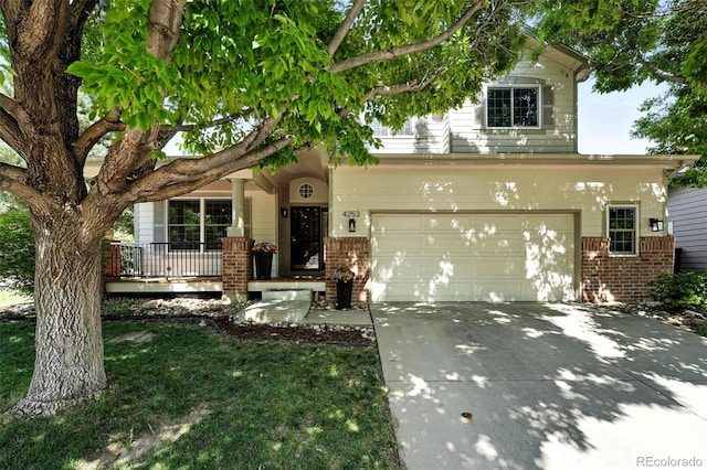 4253 Lark Sparrow St, Highlands Ranch, CO 80126 - view of front of home with brick siding, concrete driveway, a garage, and covered porch