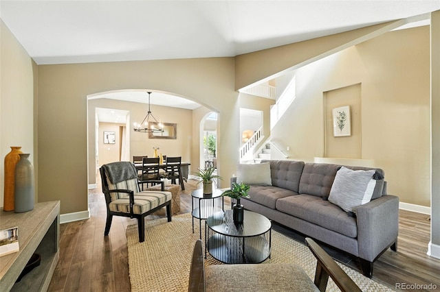4253 Lark Sparrow St, Highlands Ranch, CO 80126 - living area featuring arched walkways, dark wood-style flooring, stairs, a chandelier, and lofted ceiling