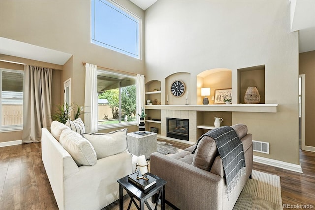 4253 Lark Sparrow St, Highlands Ranch, CO 80126 - living area featuring a towering ceiling, wood finished floors, a tiled fireplace, and built in features