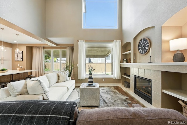 4253 Lark Sparrow St, Highlands Ranch, CO 80126 - living area with a high ceiling, built in features, wood finished floors, and a fireplace