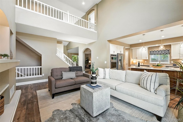 4253 Lark Sparrow St, Highlands Ranch, CO 80126 - living room with wood finished floors, stairway, recessed lighting, a towering ceiling, and arched walkways