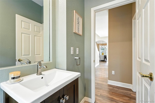 4253 Lark Sparrow St, Highlands Ranch, CO 80126 - bathroom featuring wood finished floors, vanity, and a chandelier