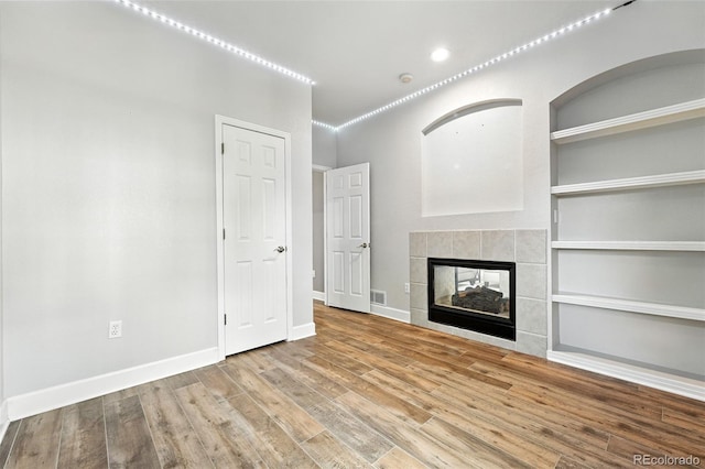 4253 Lark Sparrow St, Highlands Ranch, CO 80126 - unfurnished living room featuring wood finished floors, built in features, and a fireplace