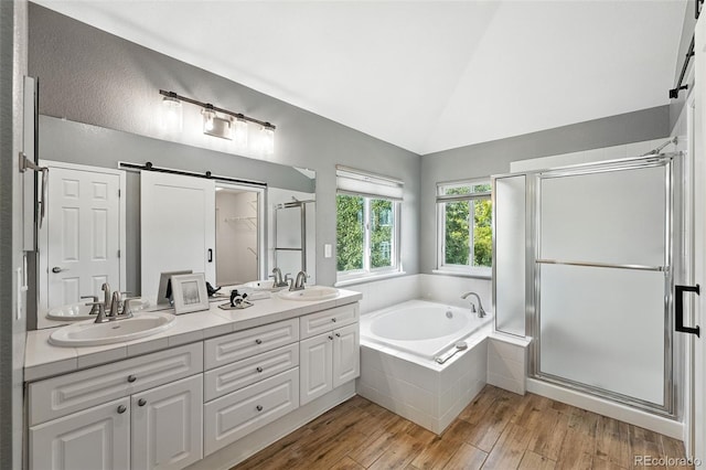 4253 Lark Sparrow St, Highlands Ranch, CO 80126 - full bathroom featuring a garden tub, double vanity, a stall shower, wood finished floors, and vaulted ceiling