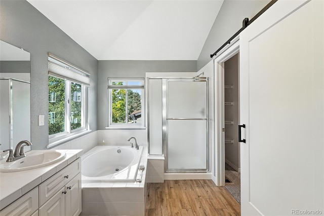 4253 Lark Sparrow St, Highlands Ranch, CO 80126 - bathroom featuring a shower stall, vanity, a garden tub, vaulted ceiling, and wood finished floors