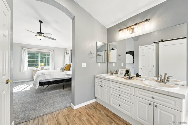 4253 Lark Sparrow St, Highlands Ranch, CO 80126 - bathroom with double vanity, wood finished floors, connected bathroom, a ceiling fan, and vaulted ceiling