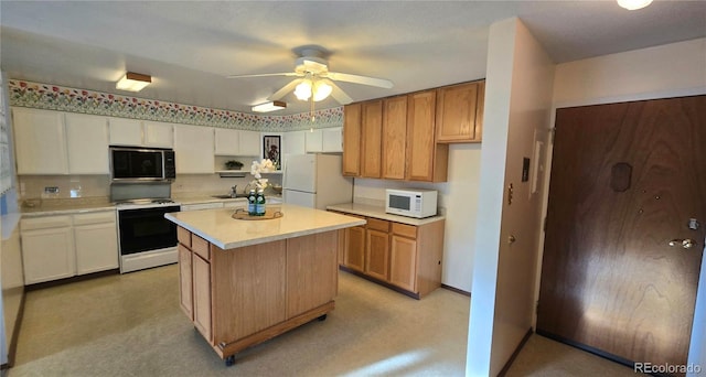 kitchen with sink, white appliances, ceiling fan, a center island, and white cabinets