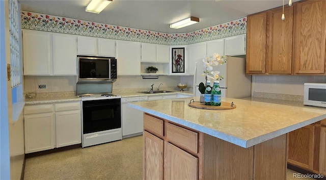 kitchen with white cabinetry, a kitchen island, sink, and white appliances