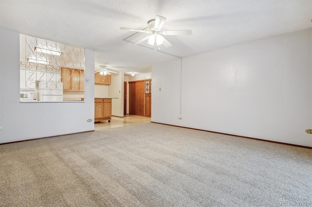 unfurnished living room with a textured ceiling, light colored carpet, and ceiling fan