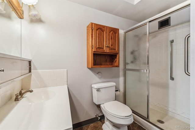 bathroom featuring toilet, an enclosed shower, and sink