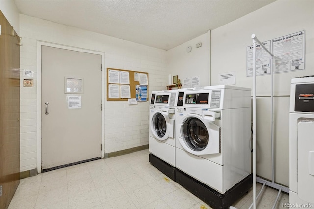 clothes washing area featuring washer and clothes dryer and a textured ceiling