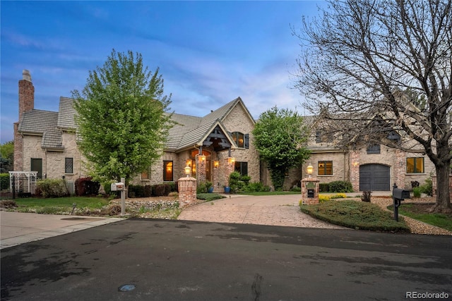 4 Redhawk Run, Englewood, CO 80113 - view of front of home with curved driveway, a chimney, and brick siding