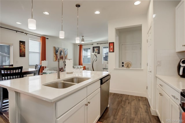 kitchen featuring a sink, tasteful backsplash, dark wood-style floors, dishwasher, and hanging light fixtures