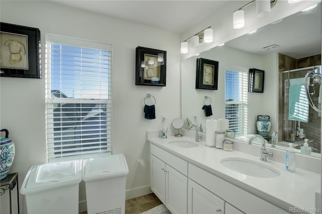 bathroom with double vanity, a stall shower, toilet, and a sink