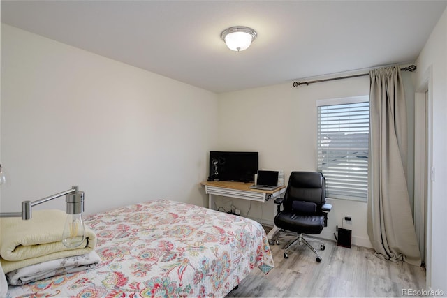 bedroom featuring baseboards and wood finished floors