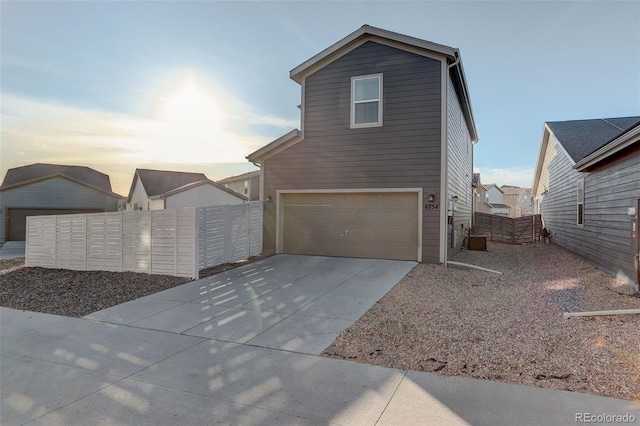 view of front of home featuring fence, a garage, and driveway