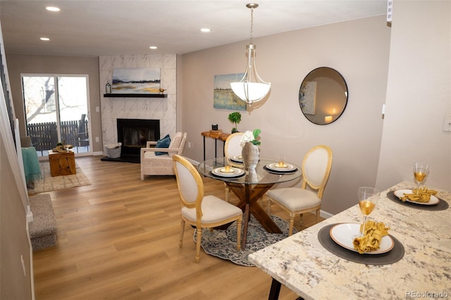 dining area with wood-type flooring and a fireplace