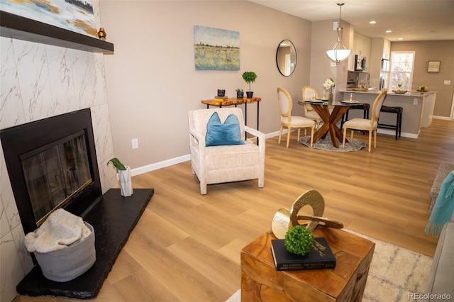 living room featuring a high end fireplace and light wood-type flooring