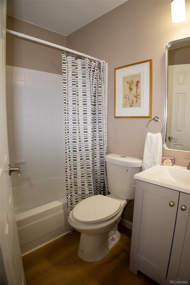 full bathroom with hardwood / wood-style flooring, shower / tub combo with curtain, vanity, and toilet