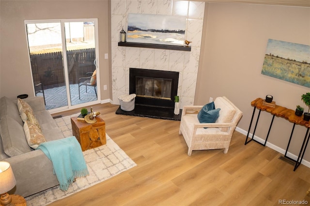 living room with a tiled fireplace and hardwood / wood-style flooring