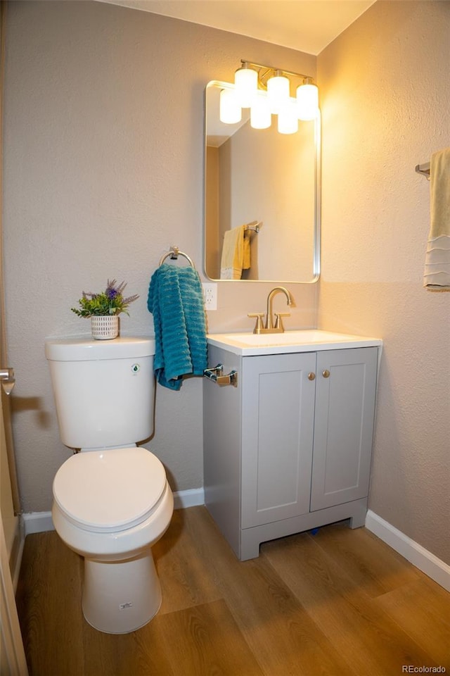 bathroom with vanity, hardwood / wood-style flooring, and toilet