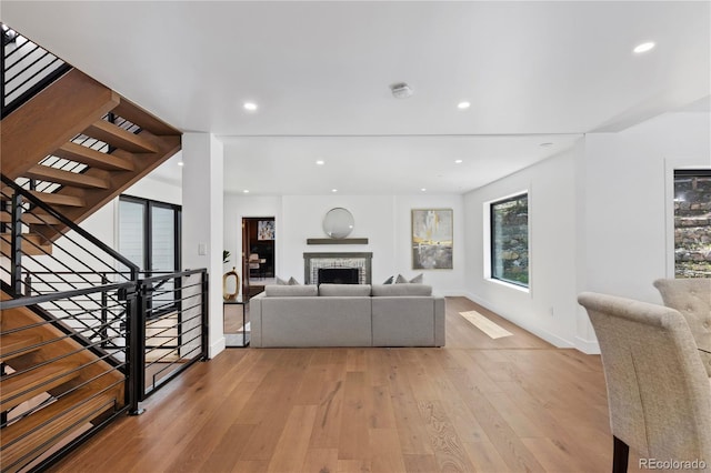 living room featuring light wood-type flooring and a stone fireplace