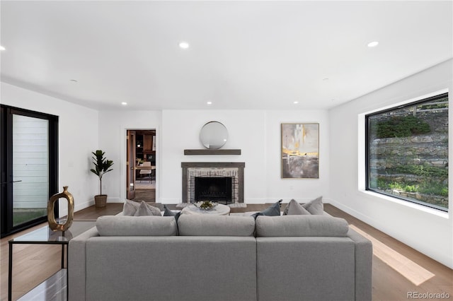 living room with hardwood / wood-style flooring and a brick fireplace