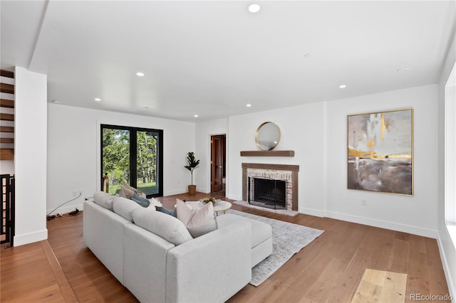 living room featuring light hardwood / wood-style floors and a brick fireplace