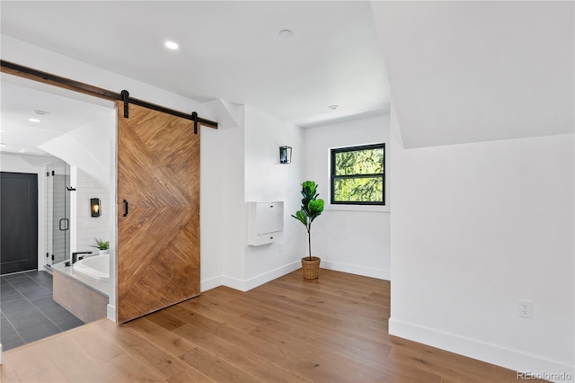 interior space with a barn door and wood-type flooring