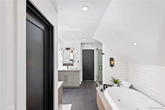 bathroom featuring tile patterned flooring, vanity, independent shower and bath, and tile walls