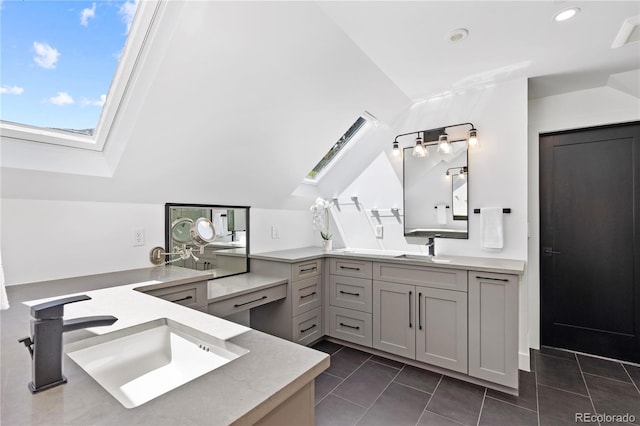 bathroom featuring tile patterned floors, lofted ceiling with skylight, and vanity