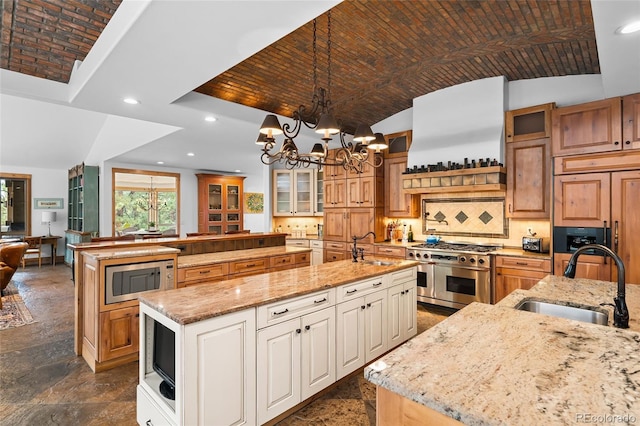 10231 Democrat Rd, Parker, CO 80134 - kitchen featuring built in appliances, a spacious island, glass insert cabinets, a chandelier, and light stone countertops
