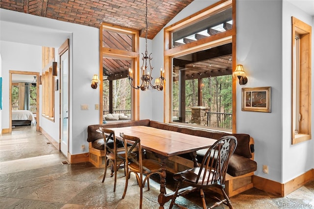 10231 Democrat Rd, Parker, CO 80134 - dining area featuring brick ceiling, stone tile flooring, a chandelier, breakfast area, and vaulted ceiling