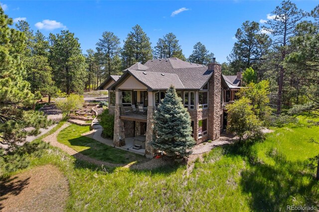 10231 Democrat Rd, Parker, CO 80134 - back of house with stone siding and a chimney