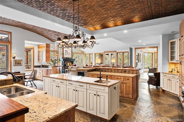 10231 Democrat Rd, Parker, CO 80134 - kitchen with an island with sink, brick ceiling, glass insert cabinets, recessed lighting, and open floor plan