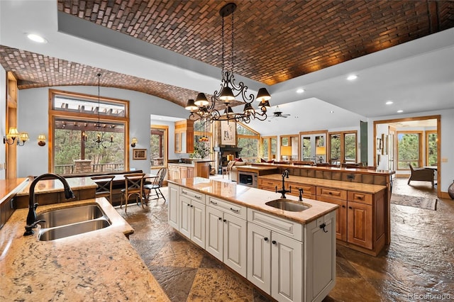 10231 Democrat Rd, Parker, CO 80134 - kitchen featuring stone tile flooring, a large island, recessed lighting, vaulted ceiling, and open floor plan